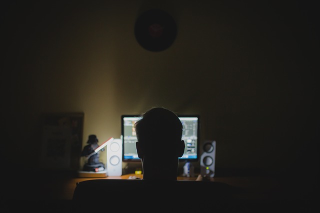 muž ve tmě za počítačem
